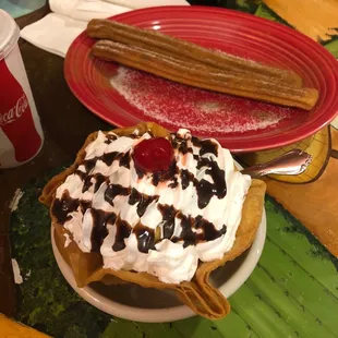 a waffle with whipped cream, chocolate sauce, and a cherry on top