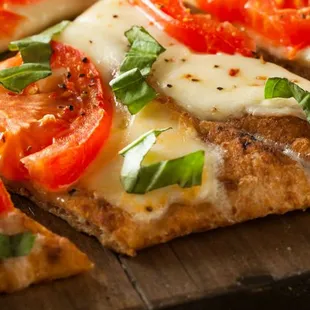 a pizza with tomatoes and basil