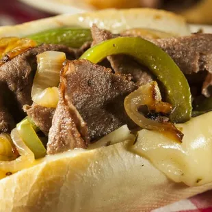 a steak sandwich with peppers and onions