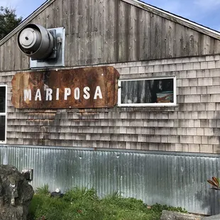 a rusty sign in front of a building