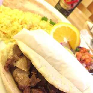 Two carnitas tacos combo with rice and beans with the pico on the side.