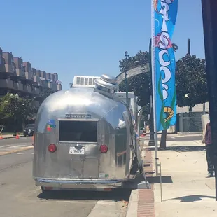 a silver airstream parked on the side of the road