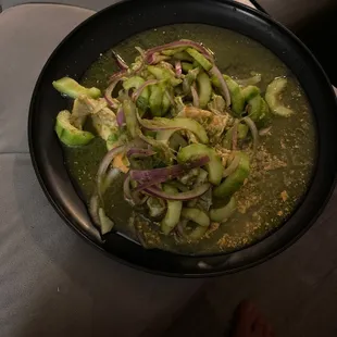 a bowl of soup with onions and cucumbers