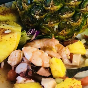 a pineapple with shrimp and vegetables