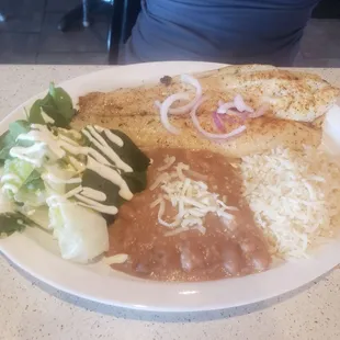 Grill fish. Sides are rice, beans, and a salad.