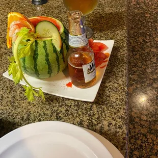 a watermelon and a drink on a plate