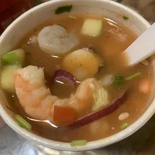 a bowl of soup with shrimp and vegetables