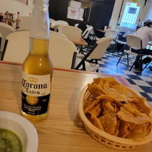 a bowl of chips and a bottle of corona beer