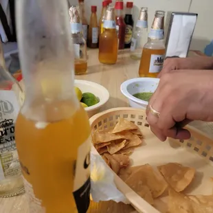 a table with chips and a bottle of beer