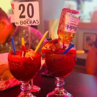 two cocktails with strawberries in them