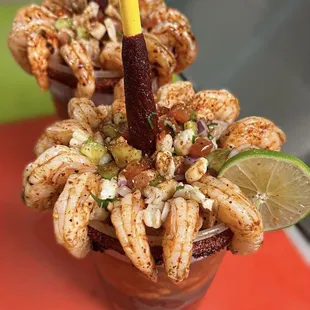 &quot;Cevichingona&quot; half Clamato preparado and half shrimp ceviche with 12 shrimped rimmed with chamoy and tajin.