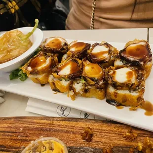 a plate of sushi rolls and a bowl of sauce