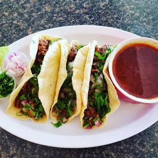 Birria Tacos and consomé .