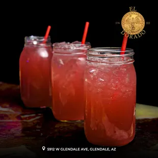 three jars of drink with straws