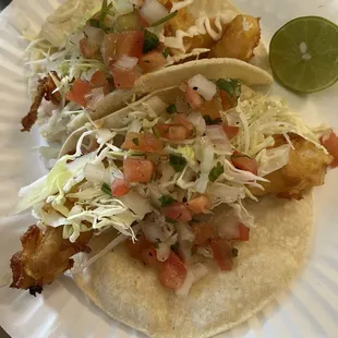 two tacos on a paper plate