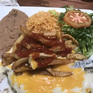 Chicken fried steak with cheese gravy, fries, rice and beans and salad.