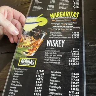 a hand holding a drink menu