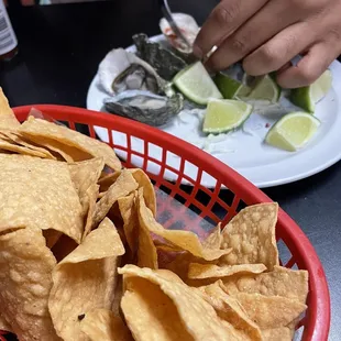 a basket of chips and a plate of oyster