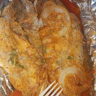a fish in foil with a fork