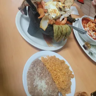 Molcajete of shrimp wrapped in bacon stuffed with cheese, breaded shrimp, chicken, steak, onions, and cactus (nopal).