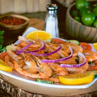 a plate of shrimp and lemons