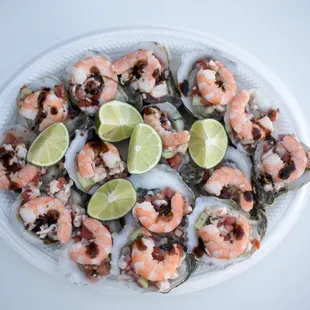 a plate of shrimp with lime wedges