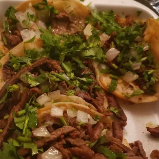 a plate of tacos with meat and vegetables