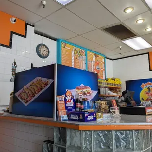 a restaurant counter with a clock on the wall
