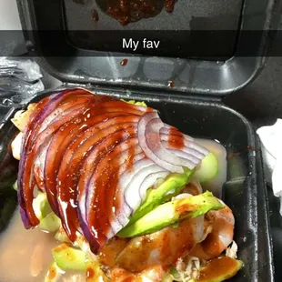 a chicken sandwich with onions and cucumbers