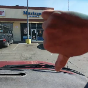 a person's thumb on the windshield of a car