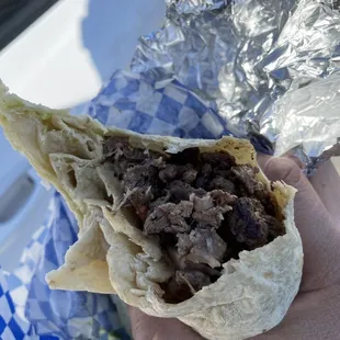 a hand holding a burrito