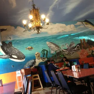 a dining room with a mural on the wall
