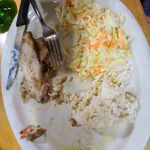 Grilled fish with rice and coleslaw.