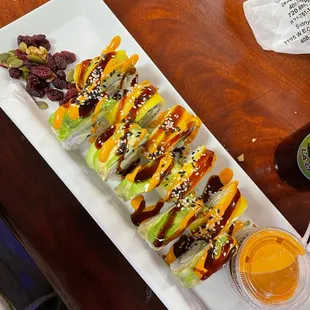 a plate of sushi rolls with a side of pickles