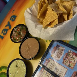 Chips with sides of pico de gallo, refried beans and a pico mix with sour cream.