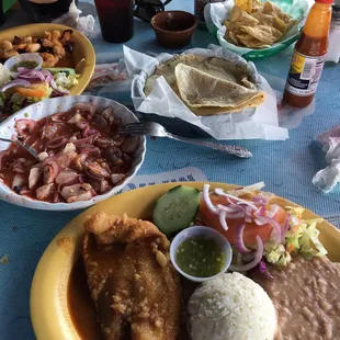 Filete al mojo de ajo extremely salty, refried beans (my favorite part) white rice and salad the green sauce was also super good