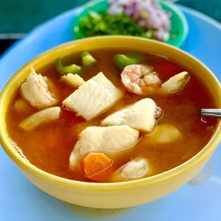 a bowl of soup with shrimp and vegetables