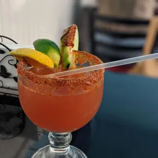a bloody drink with a garnish and lime garnish
