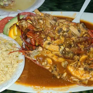 a plate of seafood with rice and vegetables