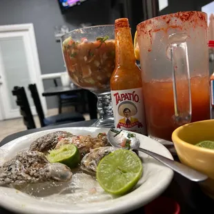 a plate of oysters and a bowl of salsa