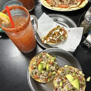 Two shrimp ceviche tostadas, taco de marlin, aguachiles, and micheladas.