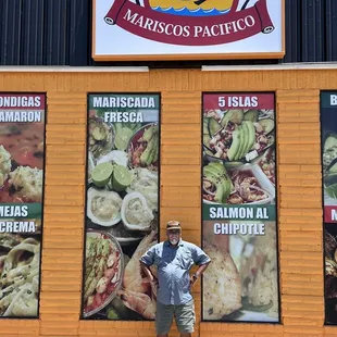 Standing outside near the entrance of the restaurant.