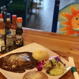 Enchiladas with mole in the top of grilled chicken.