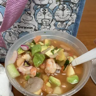 a bowl of soup with shrimp and avocado