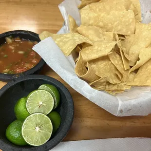 a bowl of chips and limes