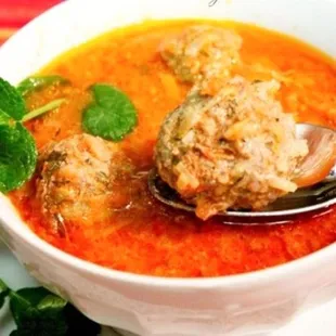 a bowl of soup with meatballs