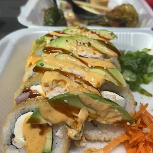 a sushi roll with avocado and sauce