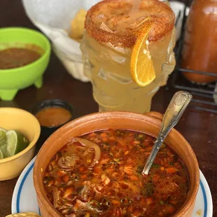 a bowl of soup with a side of tortillas