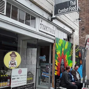 a woman sitting on a bench in front of a store