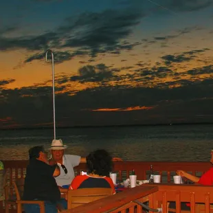 a group of people sitting at a table on a dock